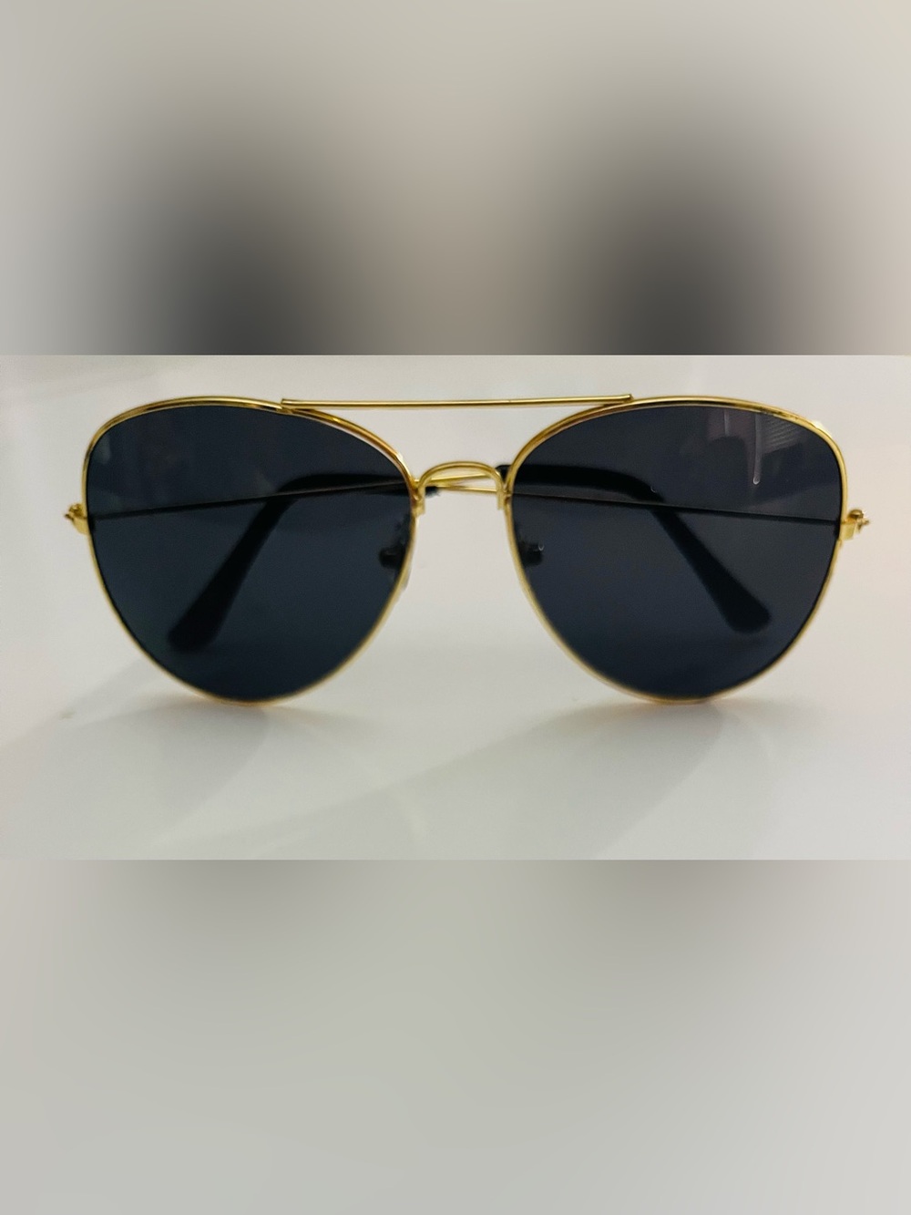 Gold frame aviator sunglasses with dark lenses.